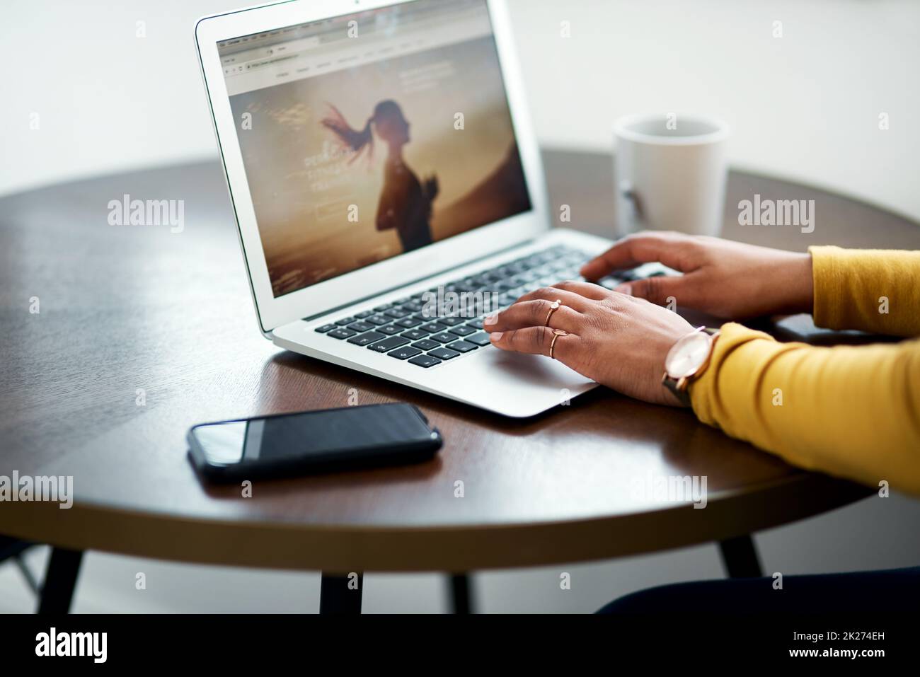 I am definitely posting this. Cropped shot of an unrecognizable woman sitting alone and using her laptop while at home. Stock Photo