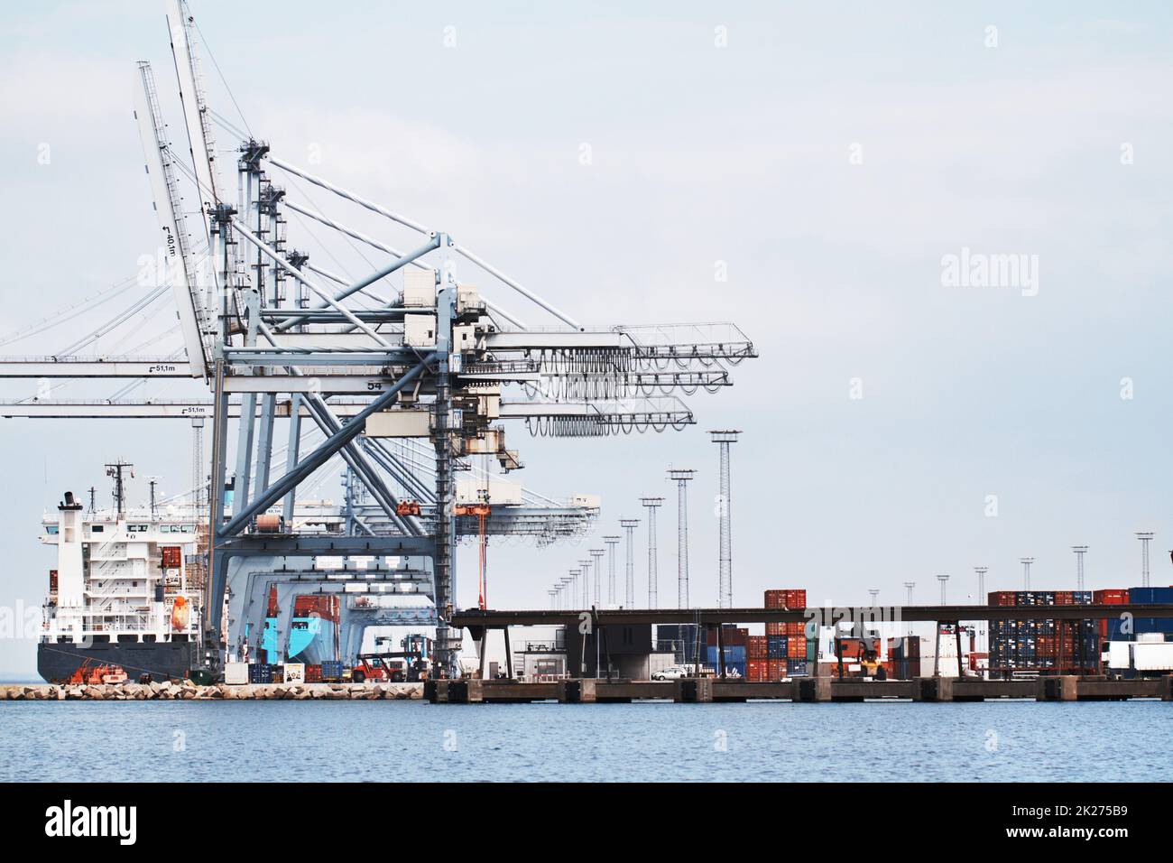 Gantry Cranes in a harbor. A photo of a harbor with anchored ships, gantry cranes and containers