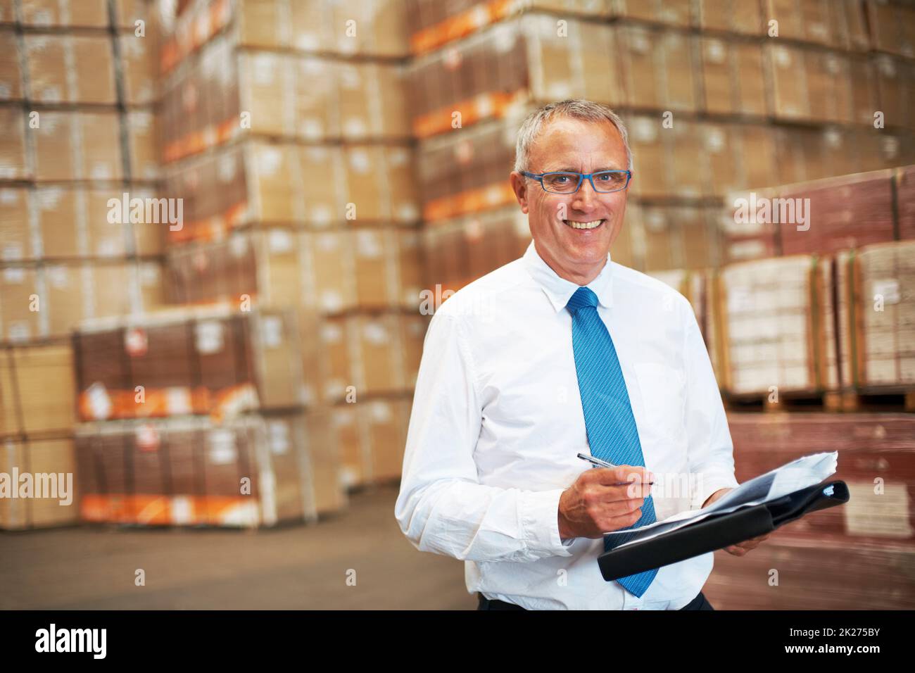 Success is grasping opportunities. A storage warehouse manager standing in the factor amidst many boxes. Stock Photo