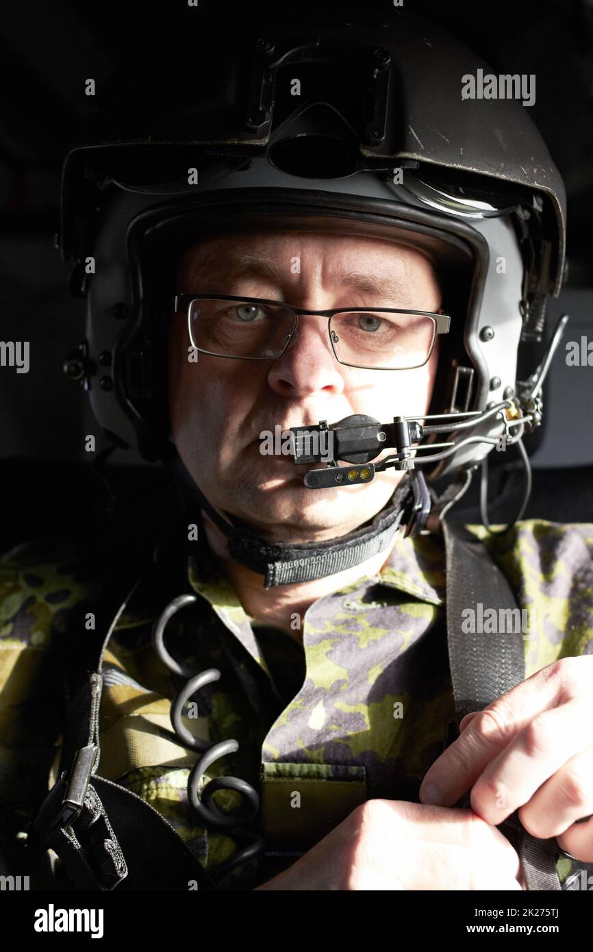Calling air to ground.... Portrait of a pilot in his aircraft wearing a helmet with a communication device. Stock Photo
