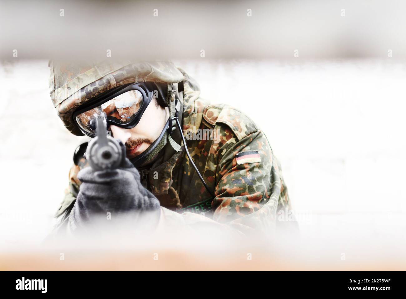 Keeping under cover. Closeup of a soldier pointing his gun at the