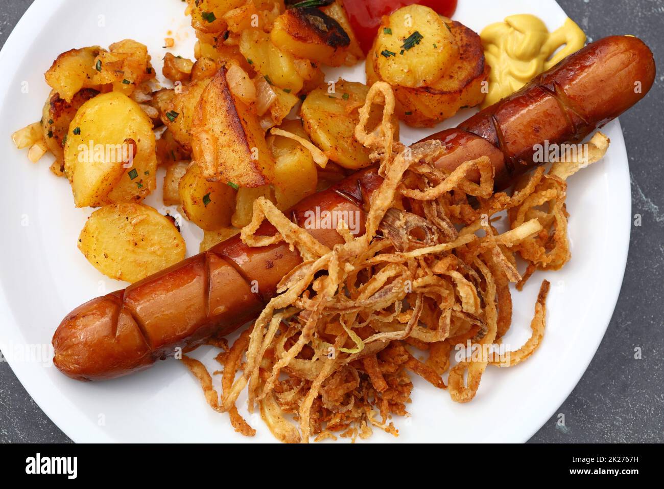 Close up portion of sausage with roasted potato Stock Photo