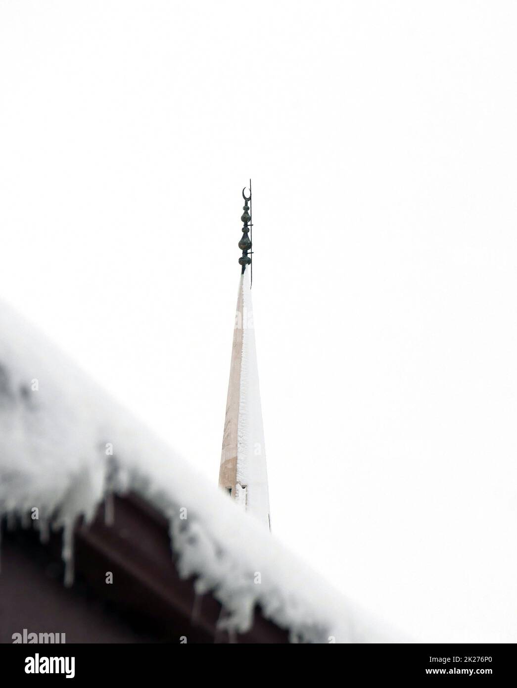 Hard Winter icicles on the roof, it's snowing, it's a hard winter, mosque minaret ...