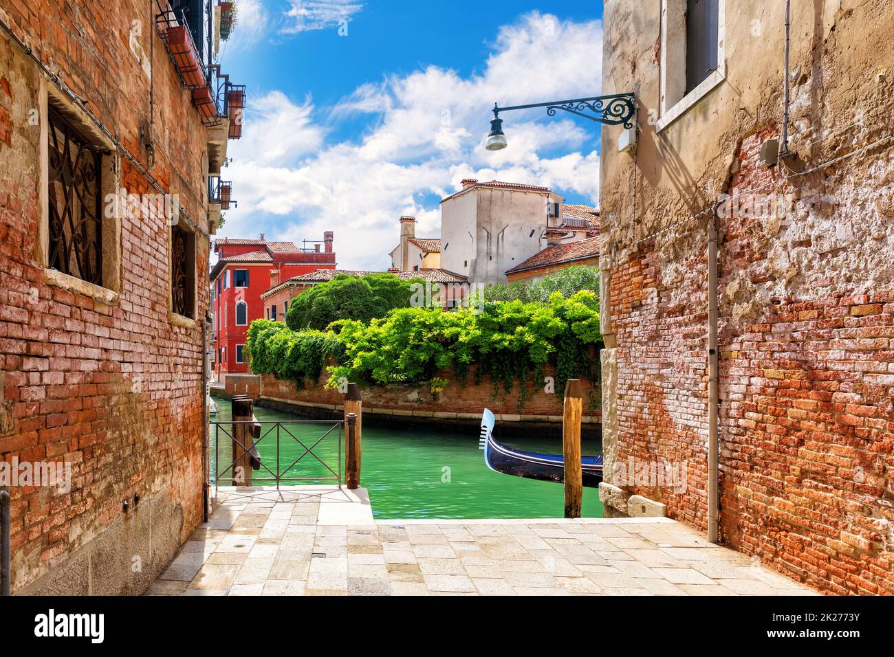 Typical narrow Italian street near the canal of Venice Stock Photo