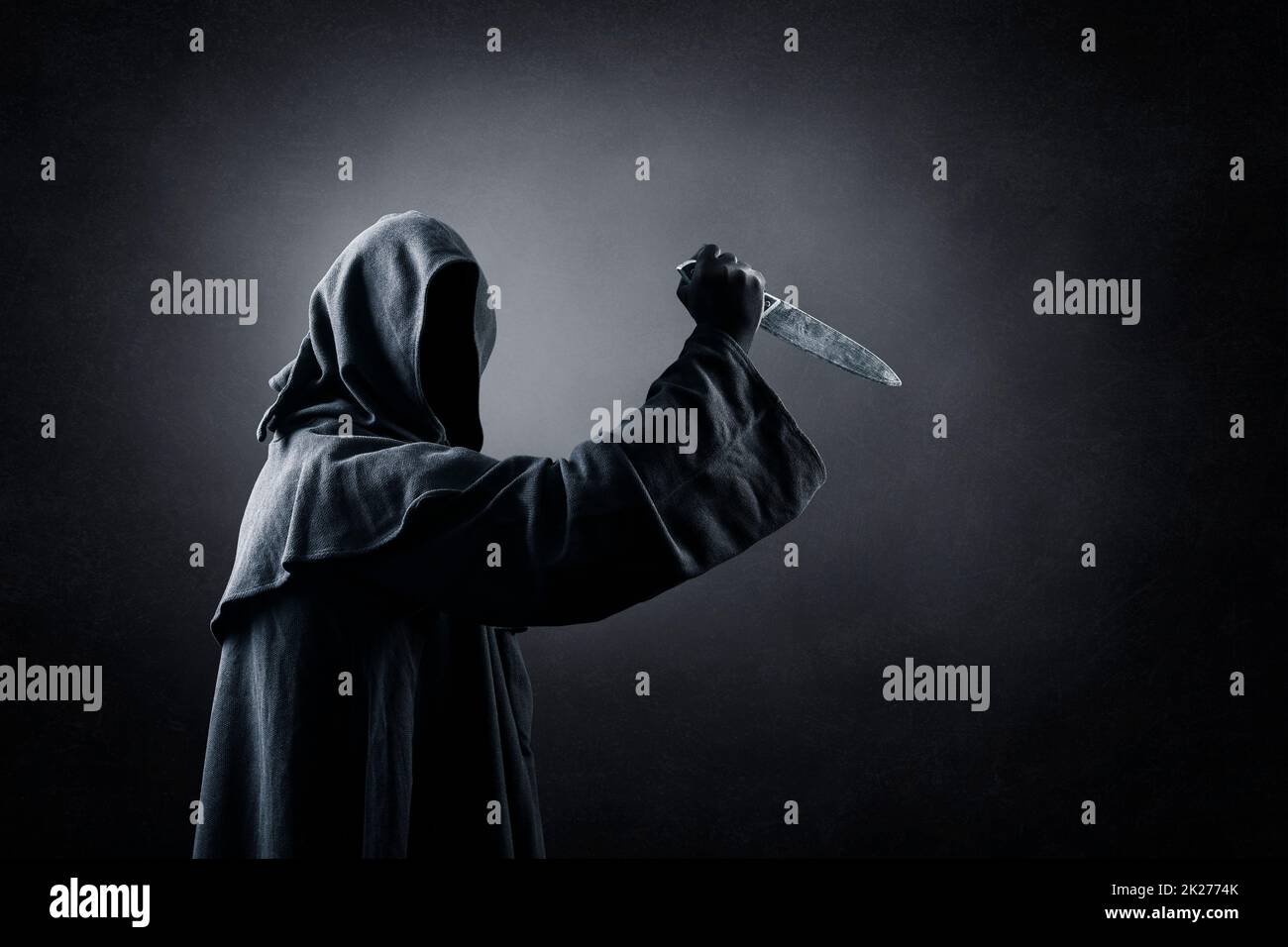 Hooded man with old knife in the dark Stock Photo - Alamy
