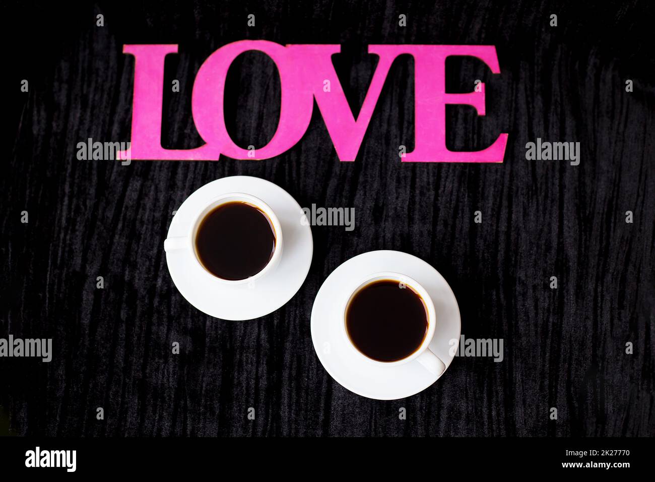 two cups of coffee on pink background inscription love Valentine's Day Stock Photo