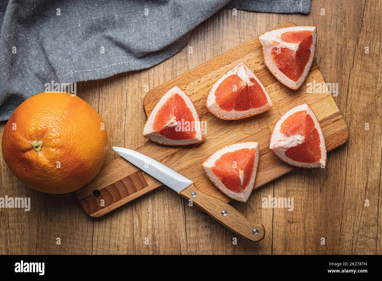 Sliced citrus fruit. Chopped fresh grapefruit on cutting board. Stock Photo