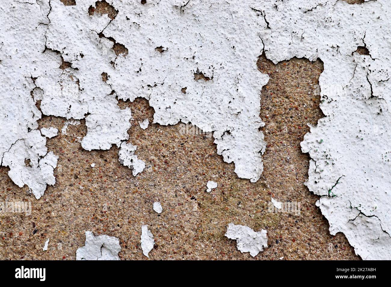 Detailed and colorful close up at cracked and peeling paint on concrete