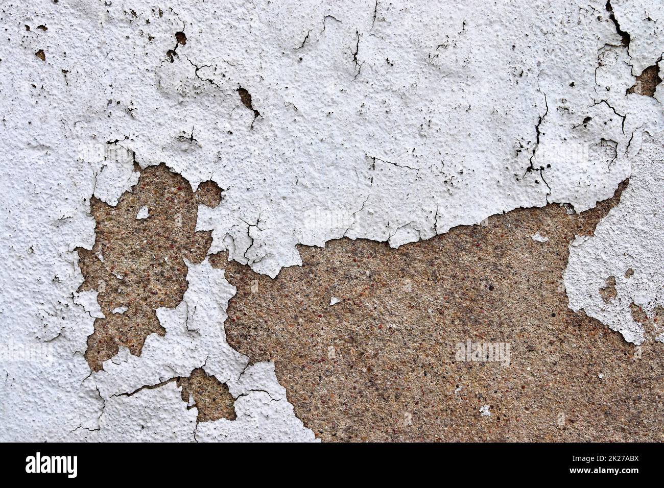 Detailed and colorful close up at cracked and peeling paint on concrete