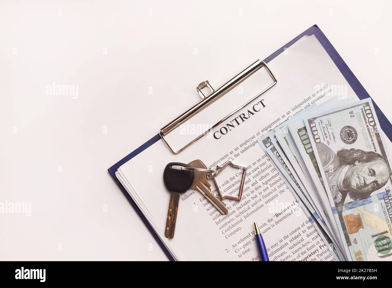 Real estate purchase contract with money and home keys on white table. Stock Photo