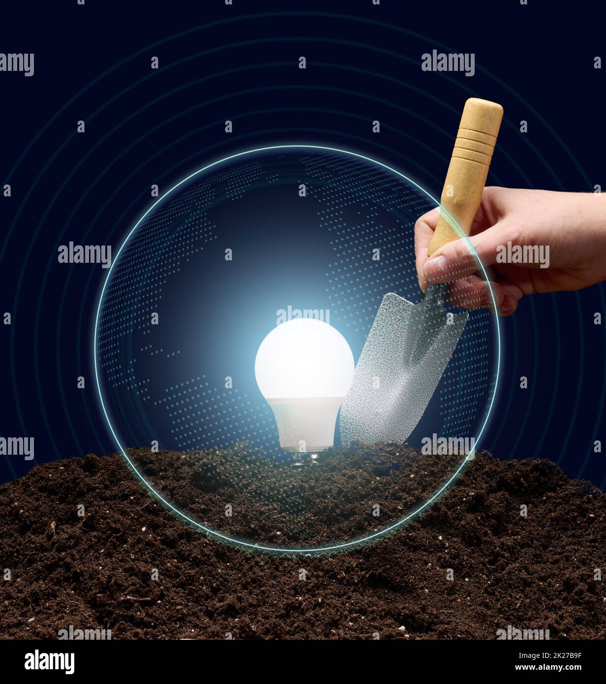 an electric lamp on the soil and a woman's hand holds a shovel. Concept of new ideas, start up Stock Photo