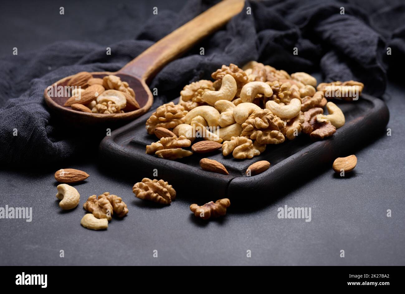 walnut, almond, cashew on a wooden board. Delicious nutritious snack Stock Photo