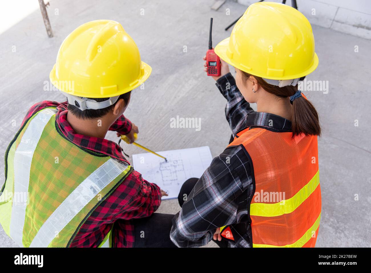 Architect and client discuss help create plan with blueprint of the building at construction site floor Stock Photo