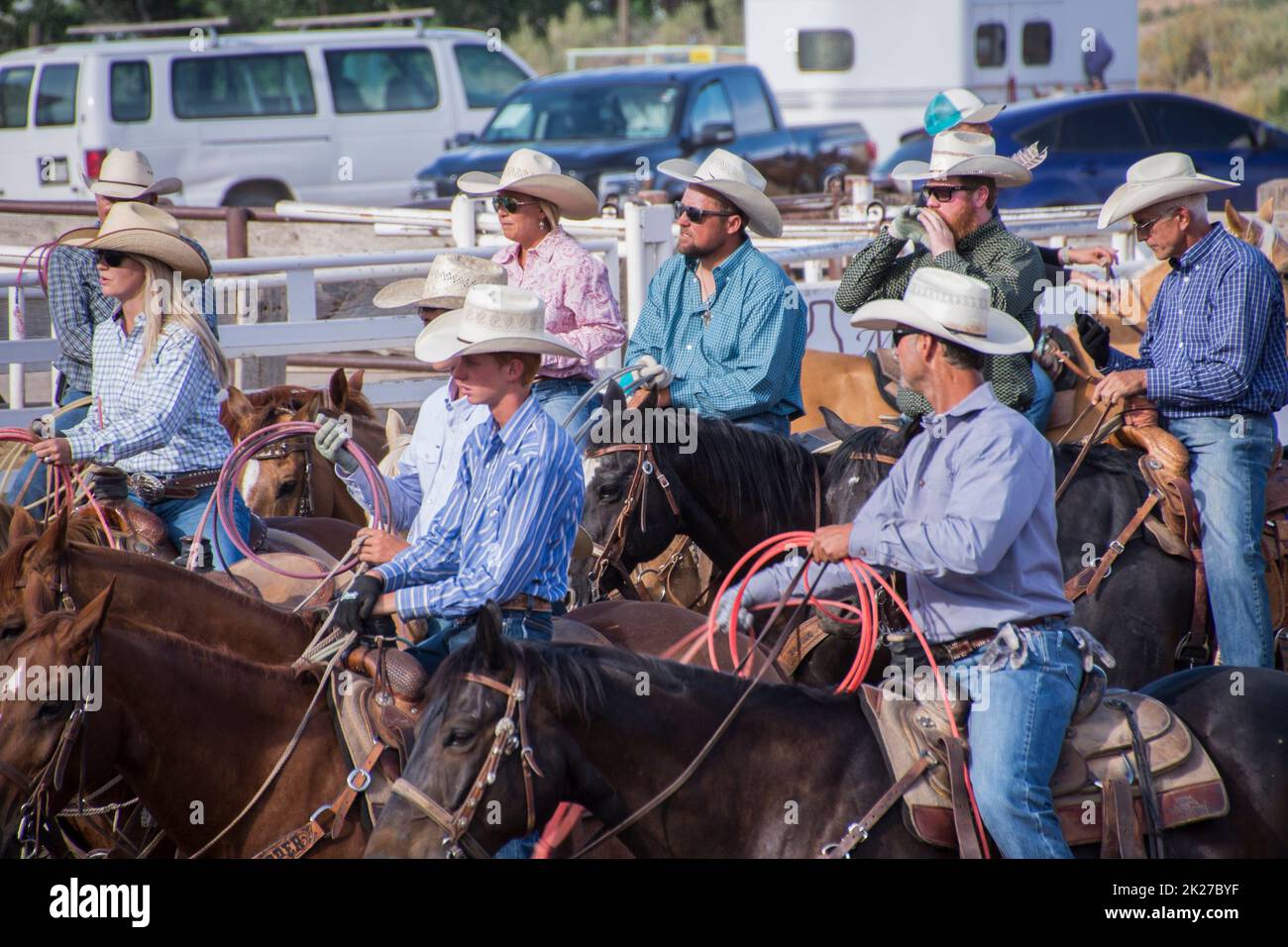 A group of cowboys and cowgirls wait their turn on their horses at a rodeo in Fruita Colorado Stock Photo