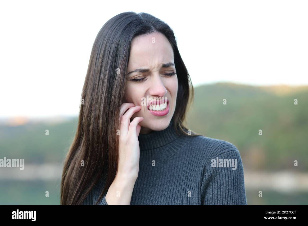 Stressed woman scratching itchy face in winter Stock Photo