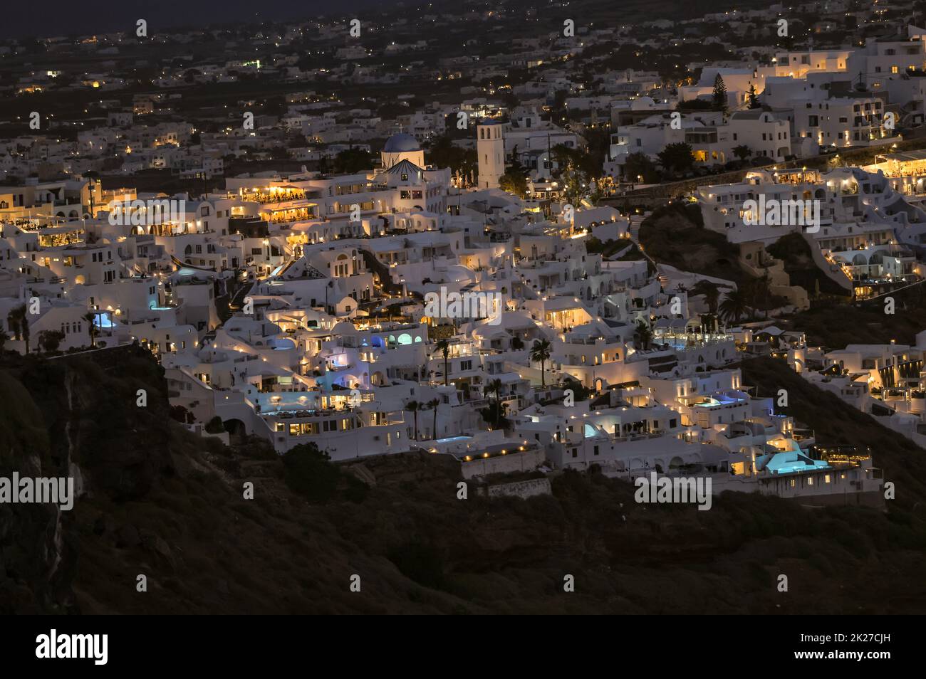 Illuminated whitewashed houses with terraces and pools and a beautiful view in Oia on Santorini island Stock Photo