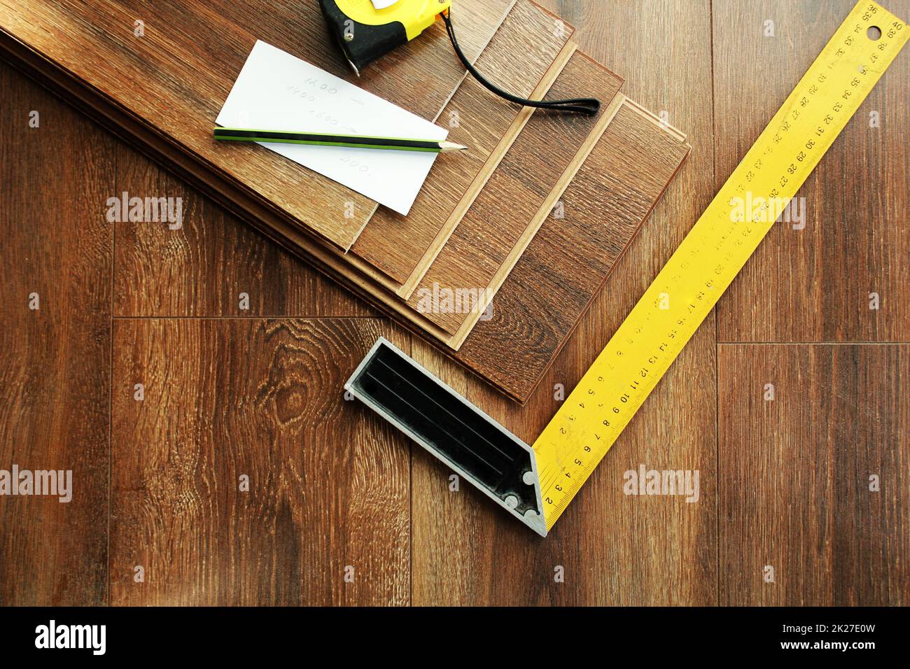Laminate floor planks and tools on wooden background. Top view. Stock Photo
