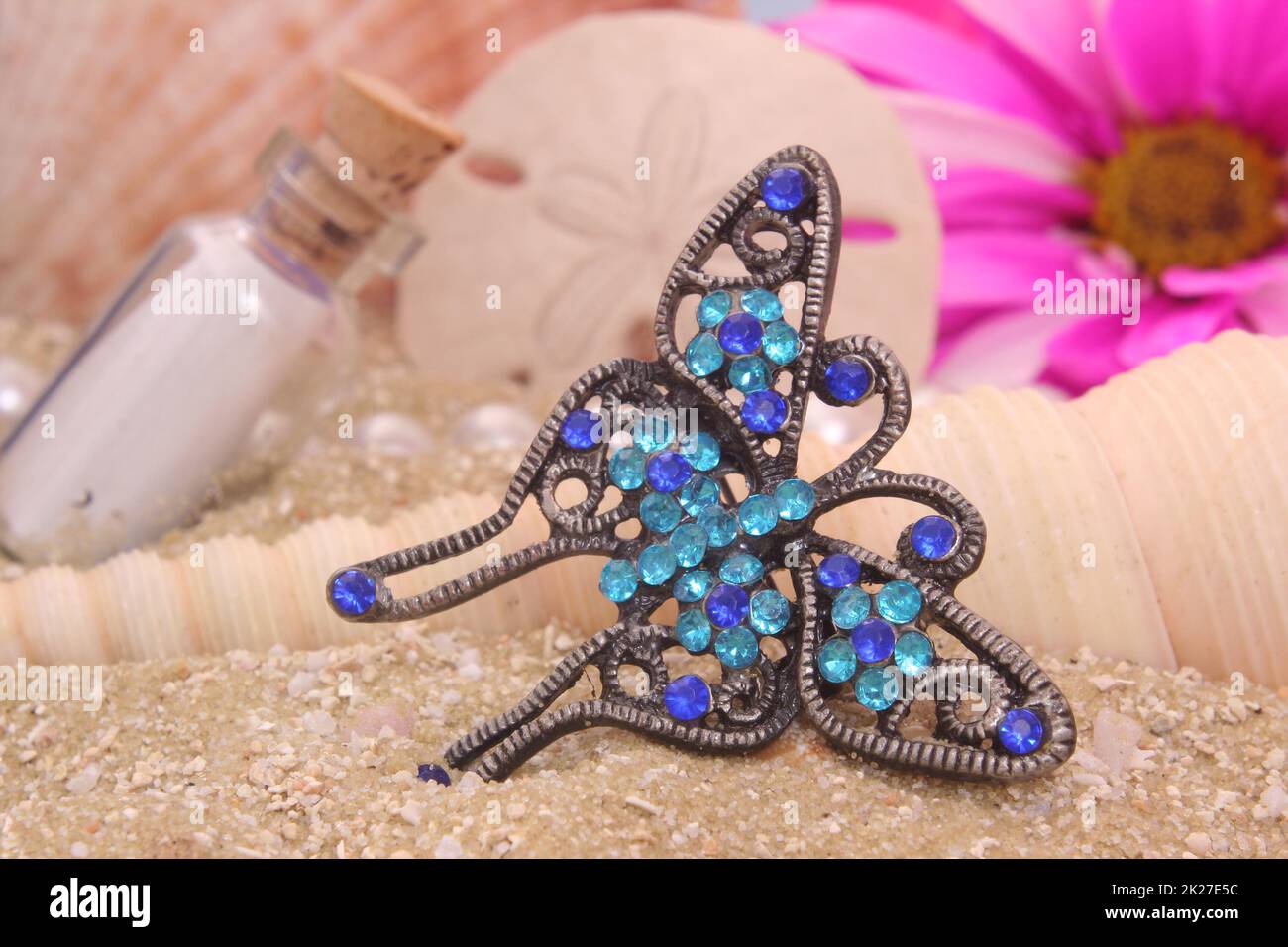 Sea Shells With Flower and Jewelry on Sandy Beach Stock Photo
