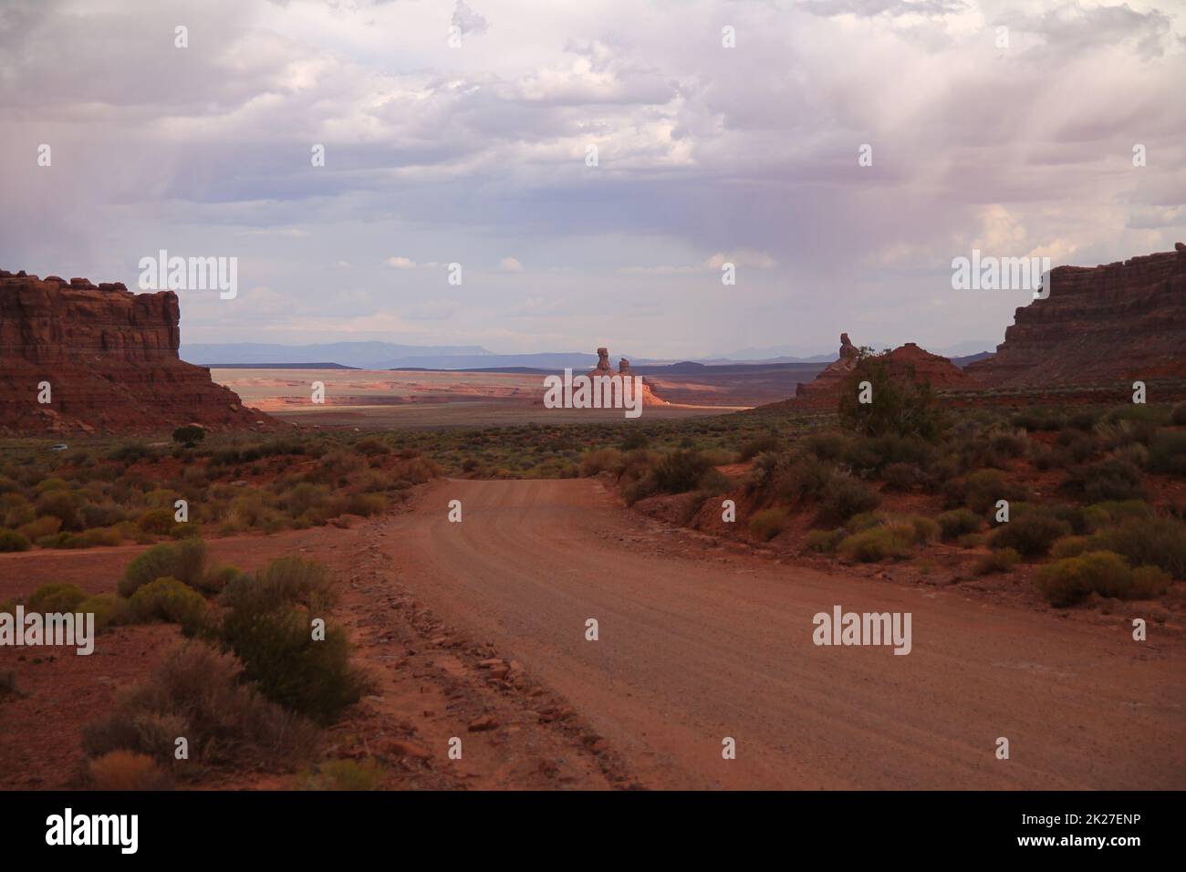The empty gravel red street and the red rock towers in the Valley of ...