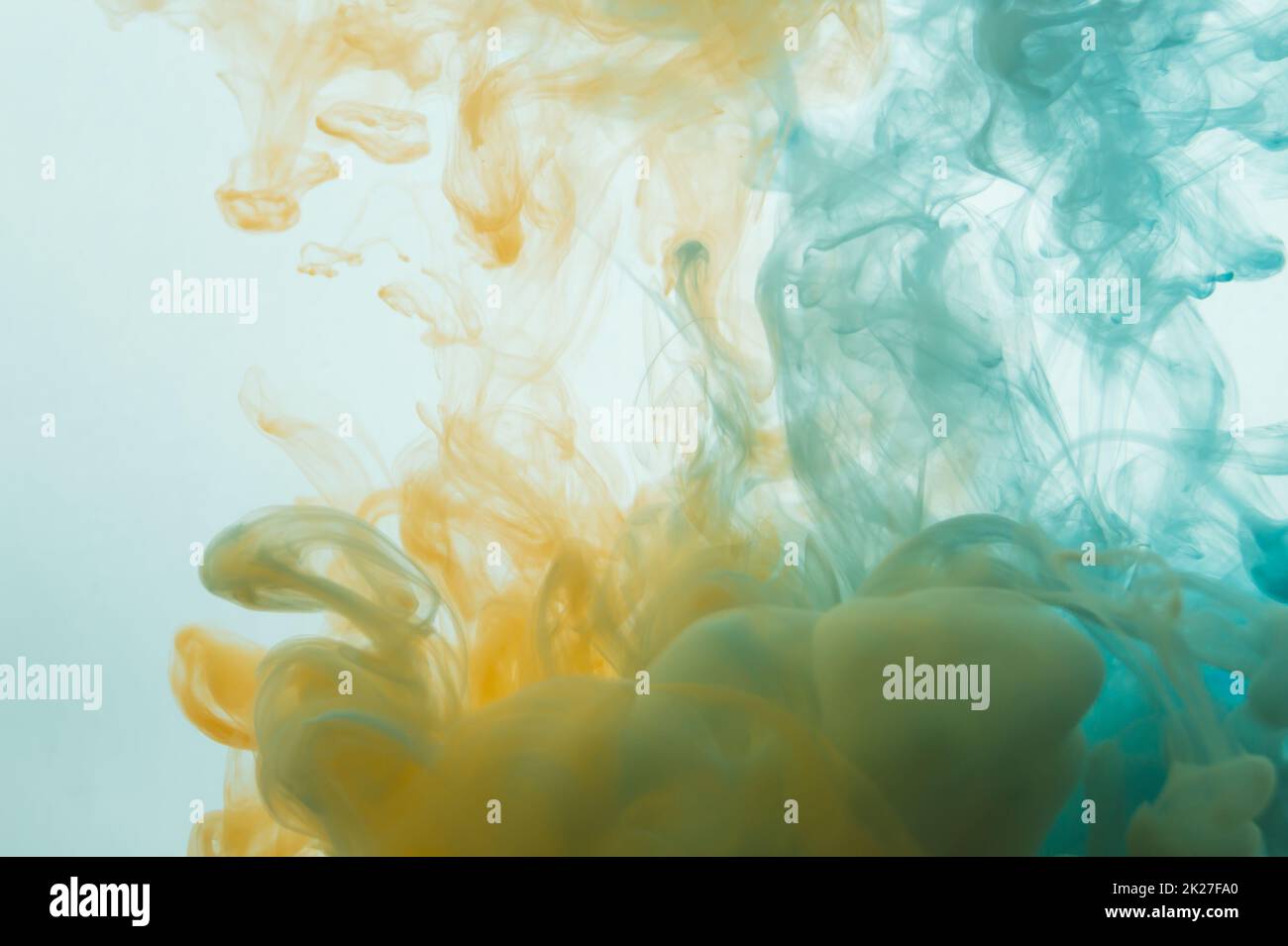 Paint in the water. abstract background. ink in fluid. colorful splashes in liquid. yellow and blue colors Stock Photo