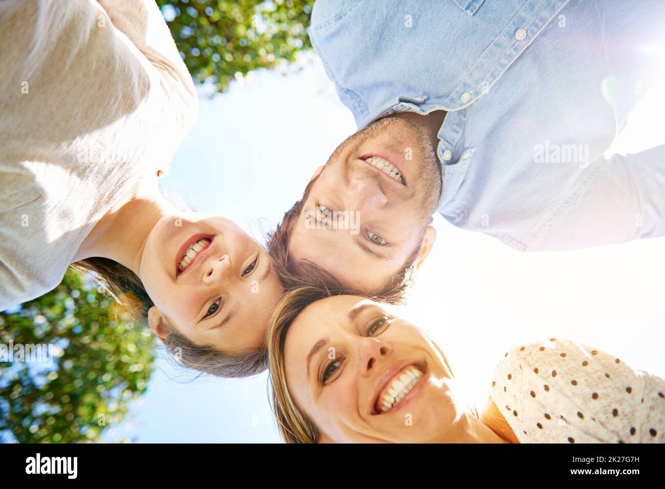 Make more time for what matters most. Portrait of a family of three looking down at the camera. Stock Photo