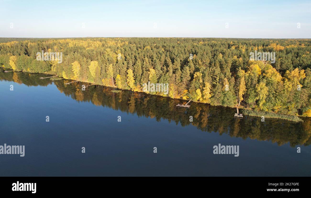 Fishing pirs in lake shore on autumn yellow background aerial view Stock Photo