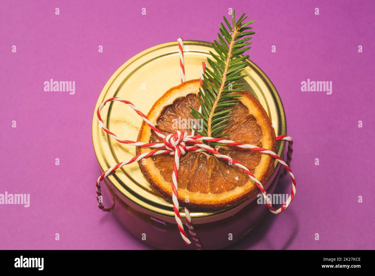 Homemade jam in a decorated jar with orange slice and fir tree twig. Winter gift Stock Photo