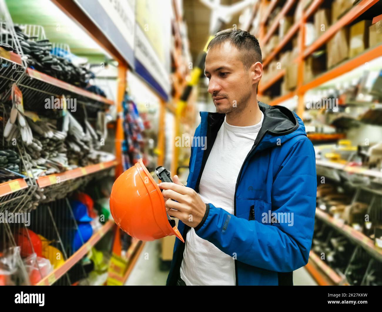 a man measures a helmet in a store Stock Photo
