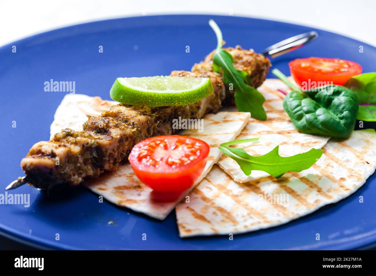 herbal meat skewer  with pita bread, tomatoes and lime Stock Photo