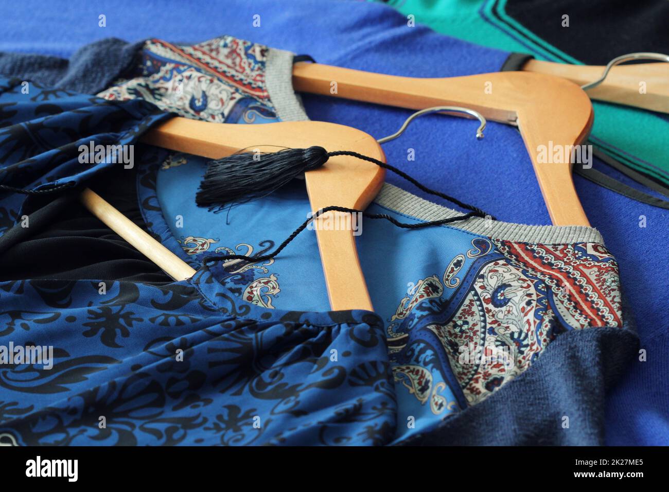 Women clothes of blue color on wooden hangers Stock Photo