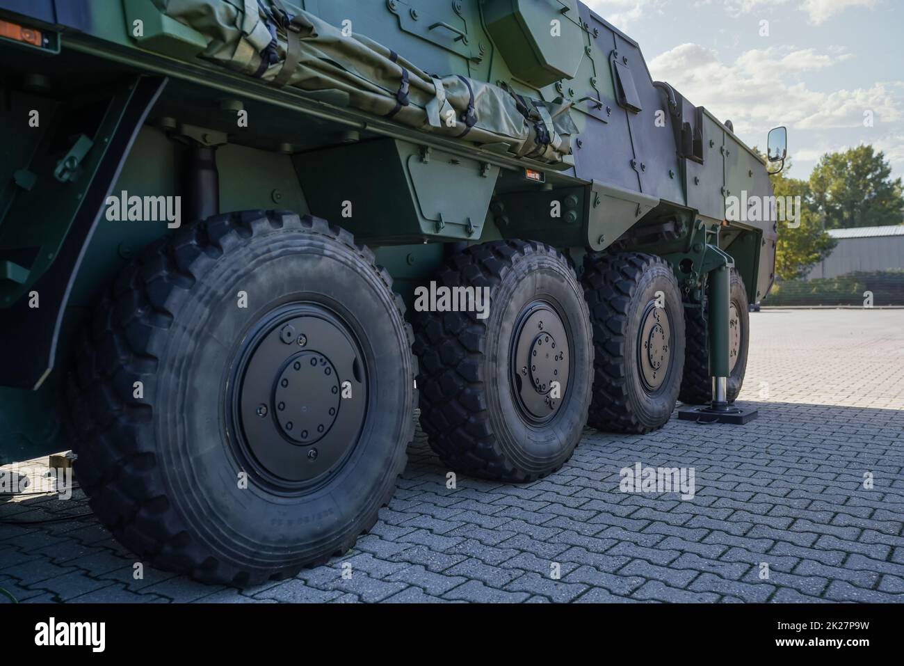Large military grade tires on green gray army vehicle, closeup detail Stock Photo
