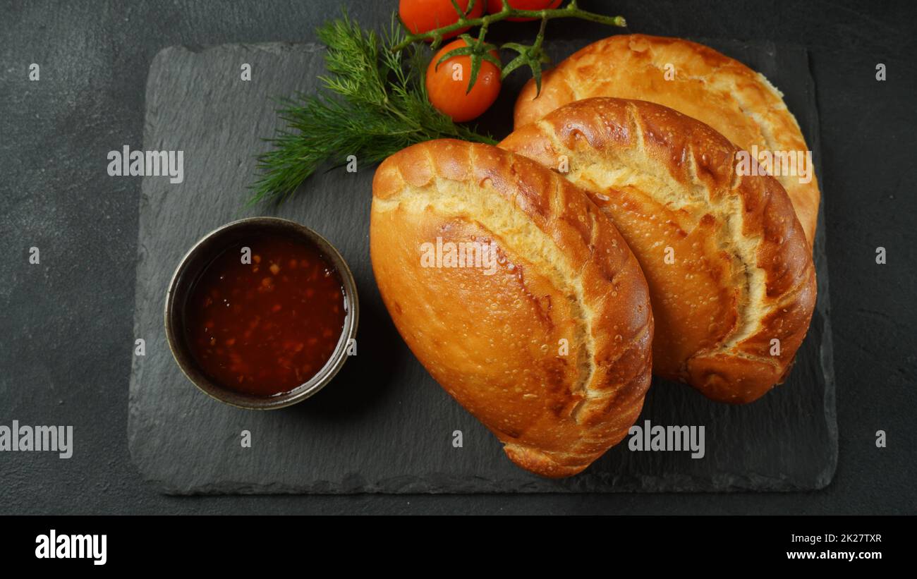 Latin American fried empanadas with tomato sauce. Argentinian Empanada is a pastry turnover filled with a variety of savory ingredients and baked or fried. Stock Photo