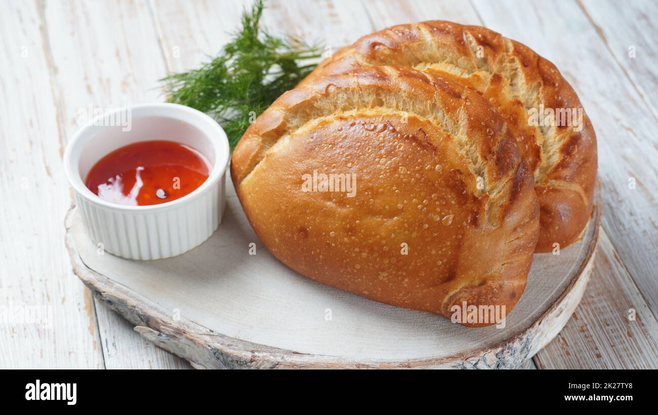 Latin American fried empanadas with tomato sauce. Argentinian Empanada is a pastry turnover filled with a variety of savory ingredients and baked or fried. Stock Photo