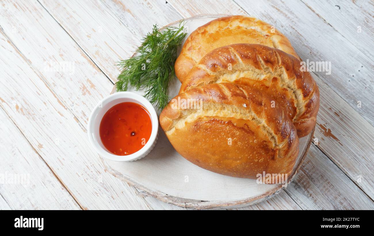 Latin American fried empanadas with tomato sauce. Argentinian Empanada is a pastry turnover filled with a variety of savory ingredients and baked or fried. Stock Photo
