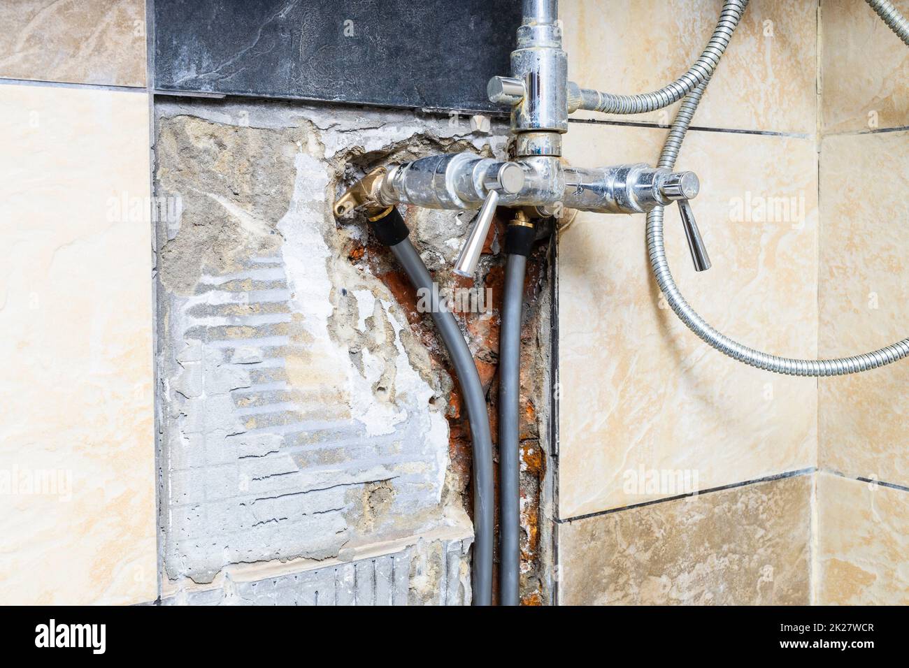 water pipes connected to faucet inside broken wall Stock Photo Alamy