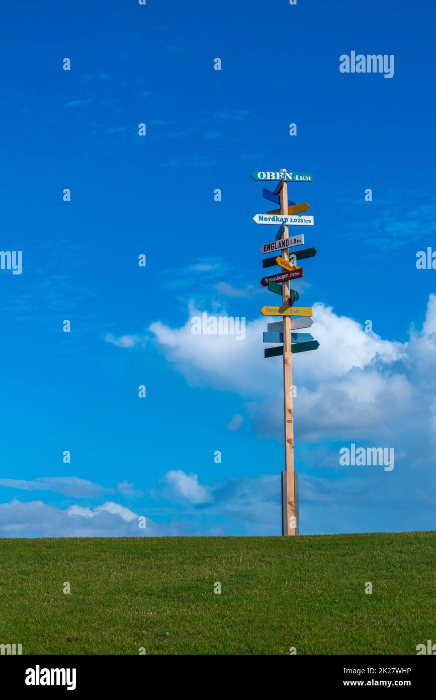 Fingerposts to the world´s main cities, on the dyke of peninsula Nordstrand, North Frisia, Schleswig-Holstein, Northern Germany, Stock Photo
