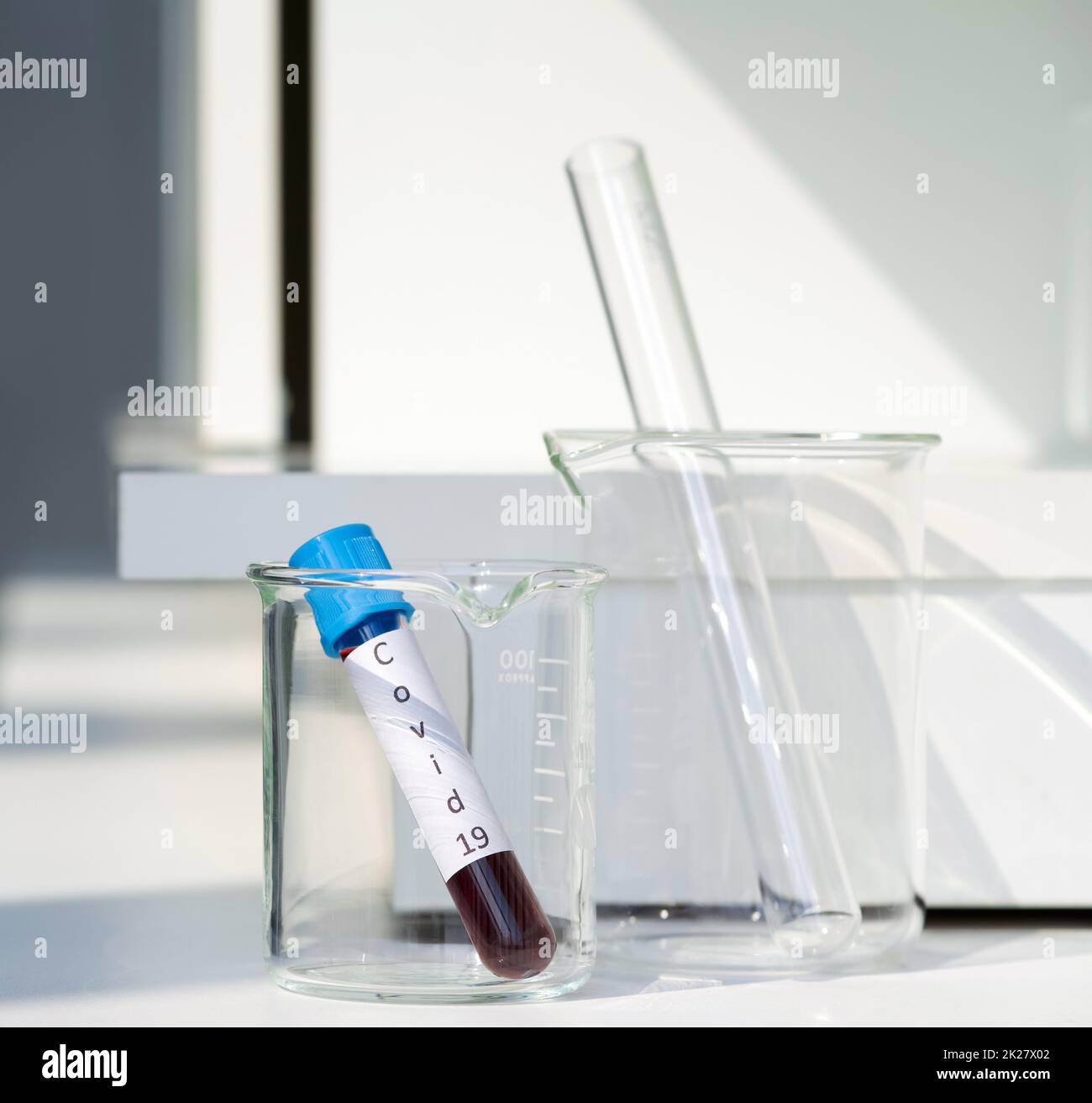 Blood collection tube from covid-19 patient on a white laboratory table. Stock Photo