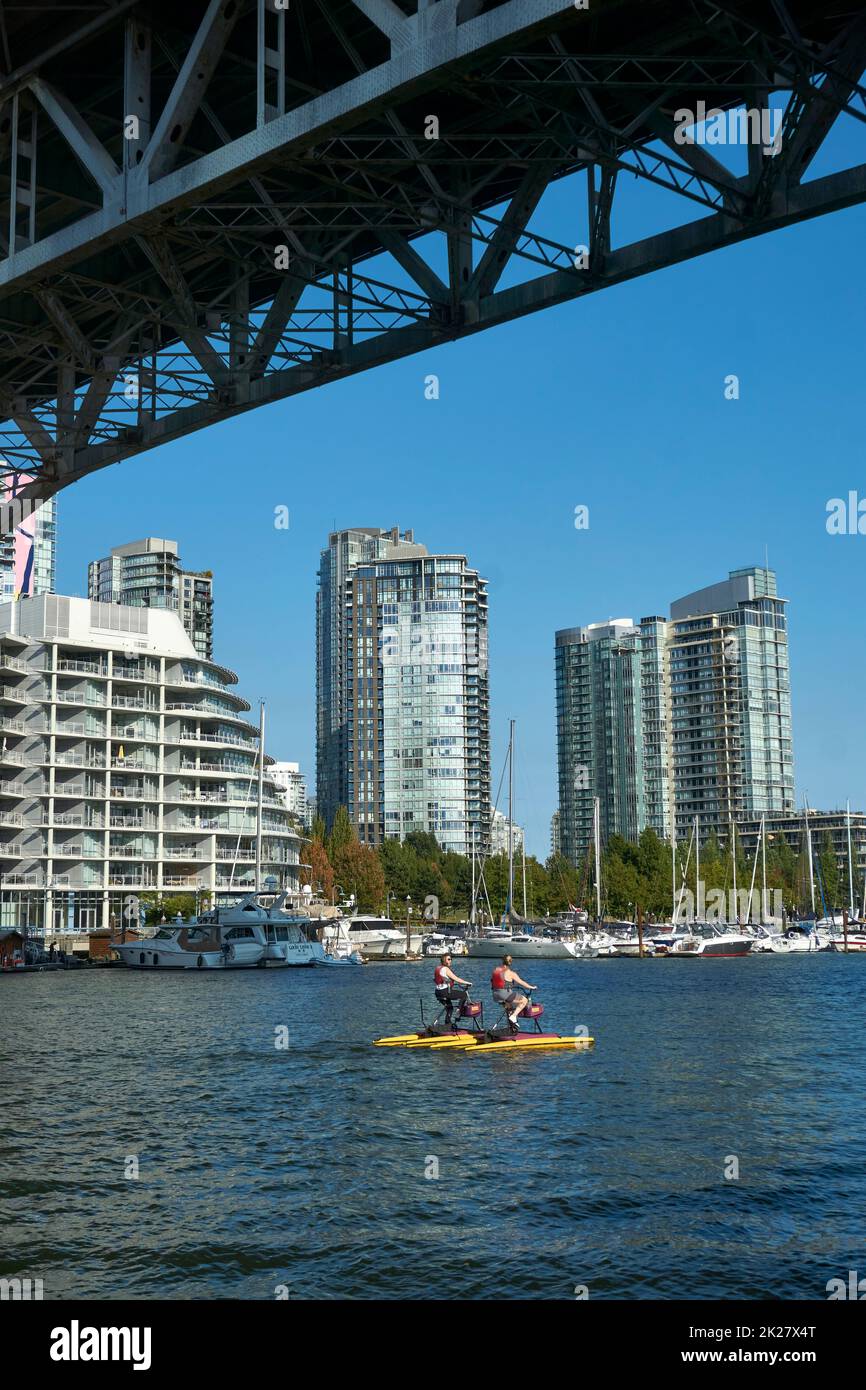 Two women riding waterbikes or hydrobikes on False Creek, Vancouver, BC, Canada Stock Photo