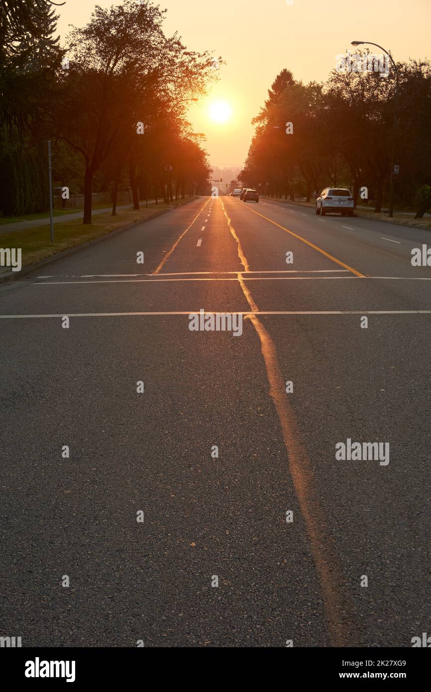 Cars on West 16th Avenue with setting sun in background, Vancouver, BC