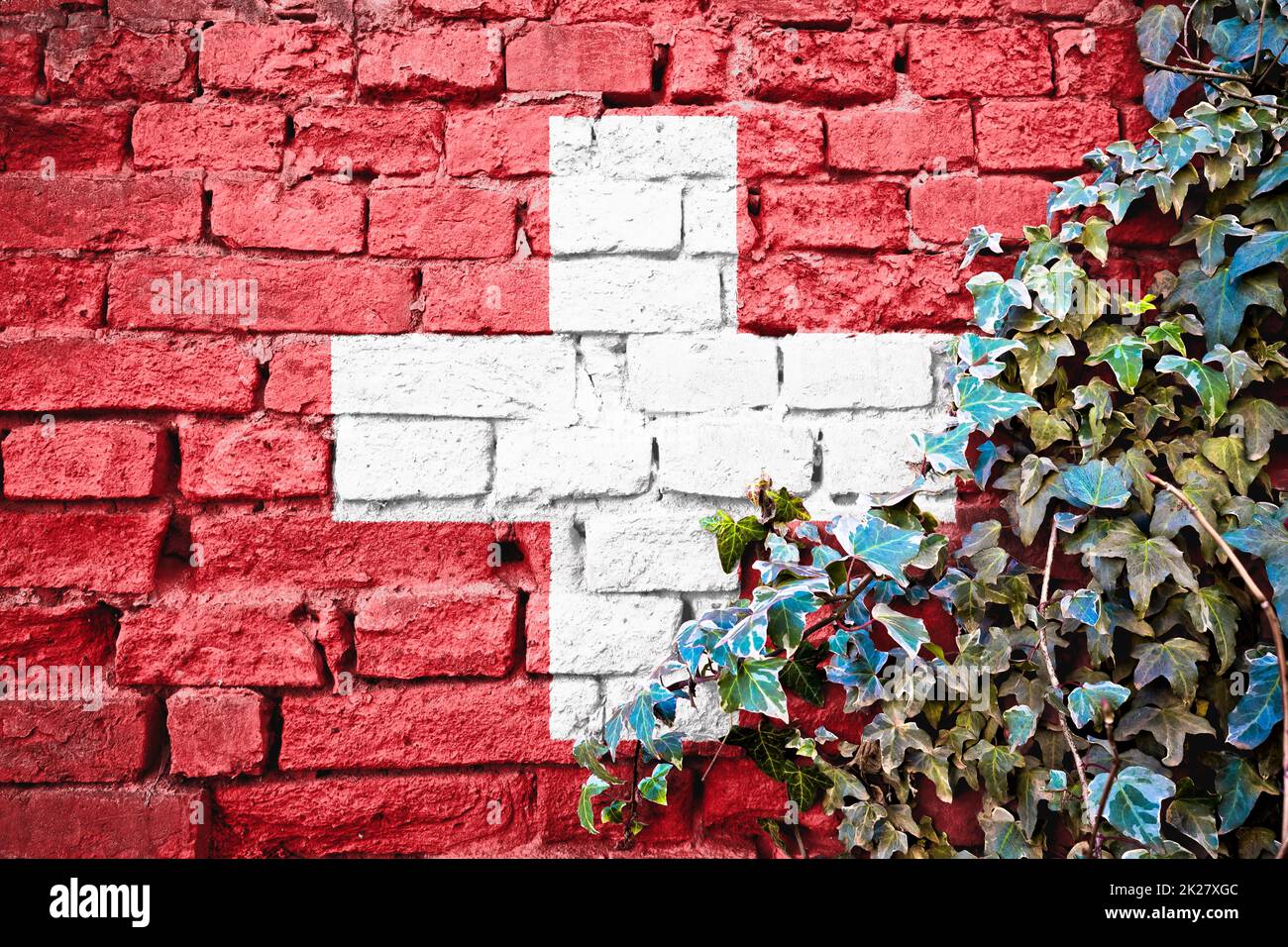 Swiss grunge flag on brick wall with ivy plant Stock Photo
