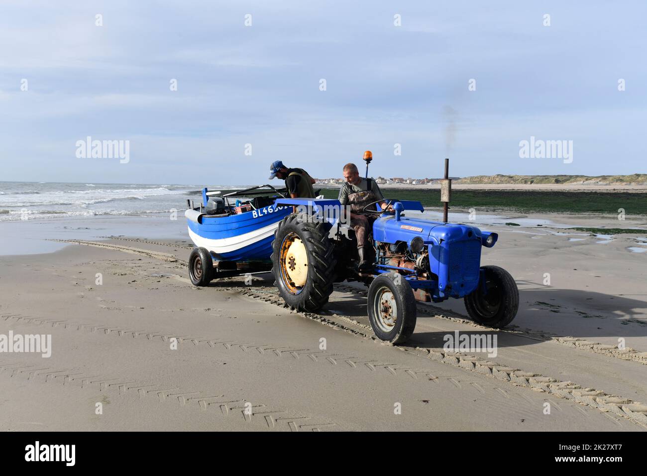 Ambleteuse beach Cote d'Opale Northern France fisherman towing boat to the sea with tractor. Stock Photo