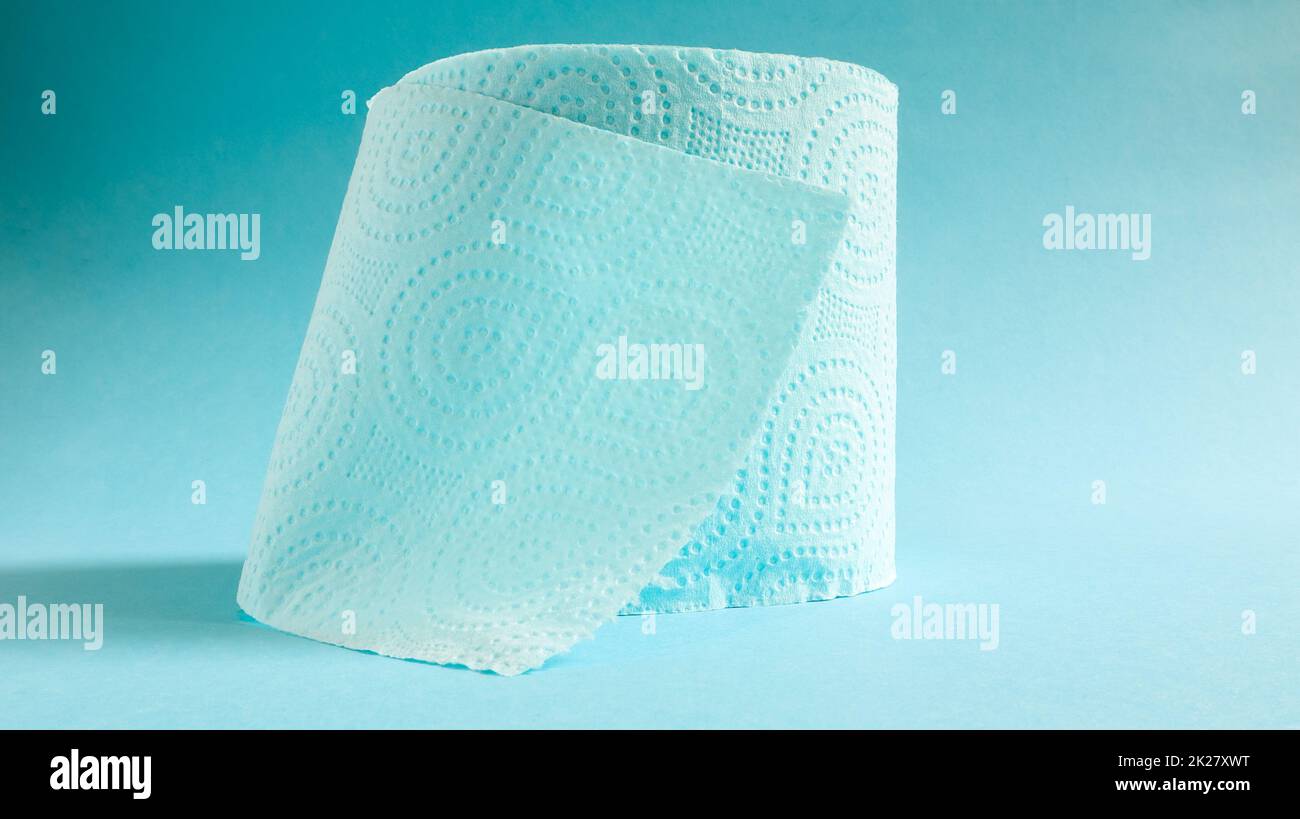 Blue roll of modern toilet paper on a blue background. A paper product on a cardboard sleeve, used for sanitary purposes from cellulose with cutouts for easy tearing. Embossed drawing Stock Photo