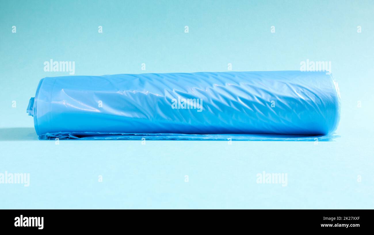 One roll of plastic garbage bags in blue on a blue background. Bags