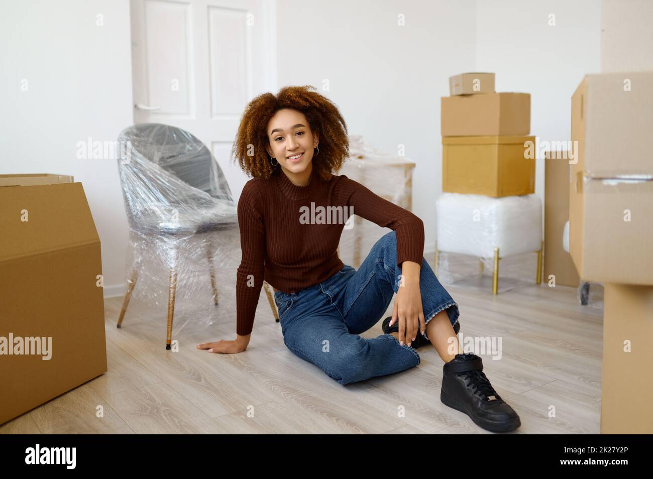 Woman sitting among carton boxes with beginnings Stock Photo