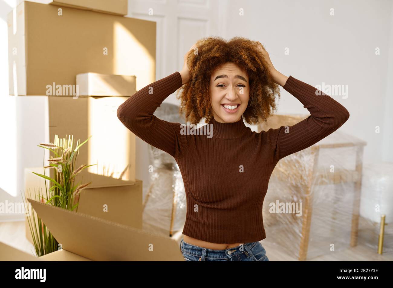 Happy but quite exhausted woman moving home Stock Photo