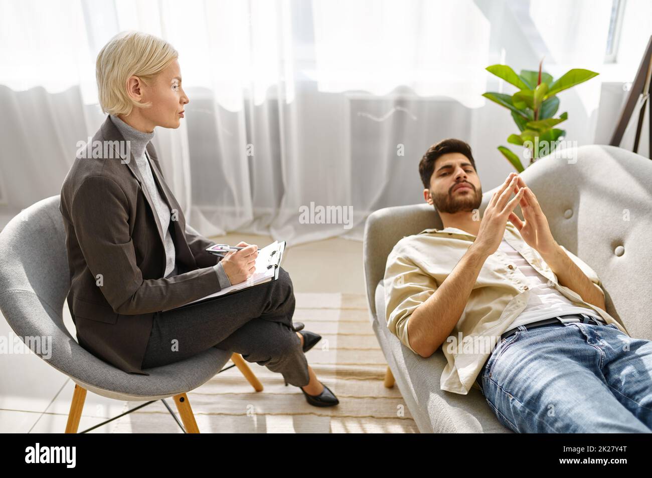 Female psychologist working with man on couch Stock Photo