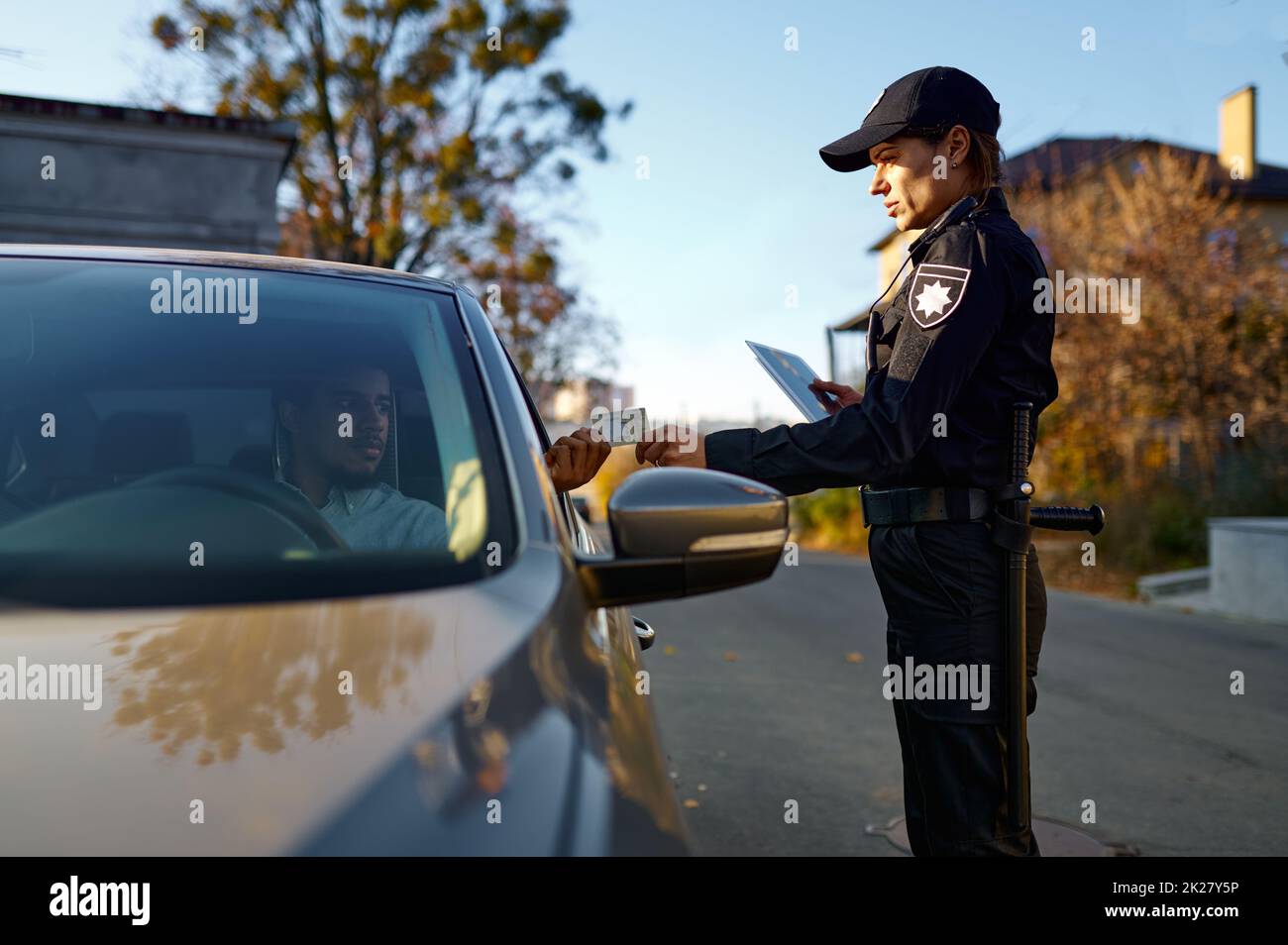 Policewoman stop car and check driver license Stock Photo