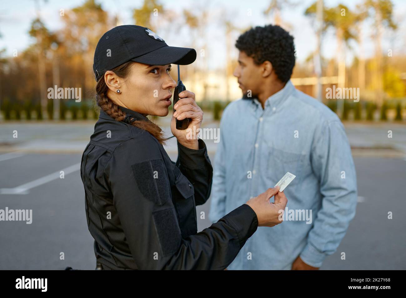 Female cop checking male passerby ID document Stock Photo
