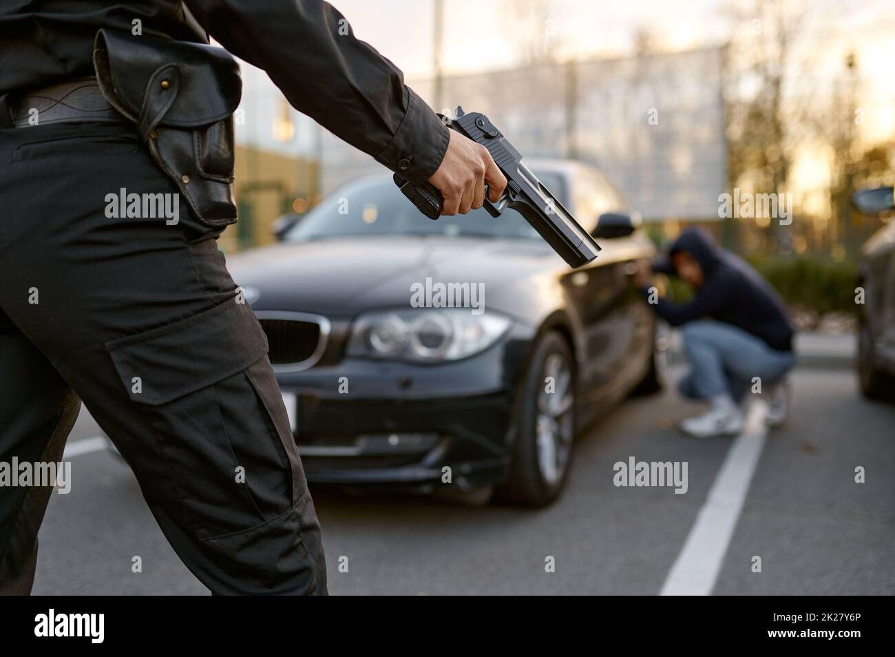 Policewoman holding gun at car thief backview Stock Photo