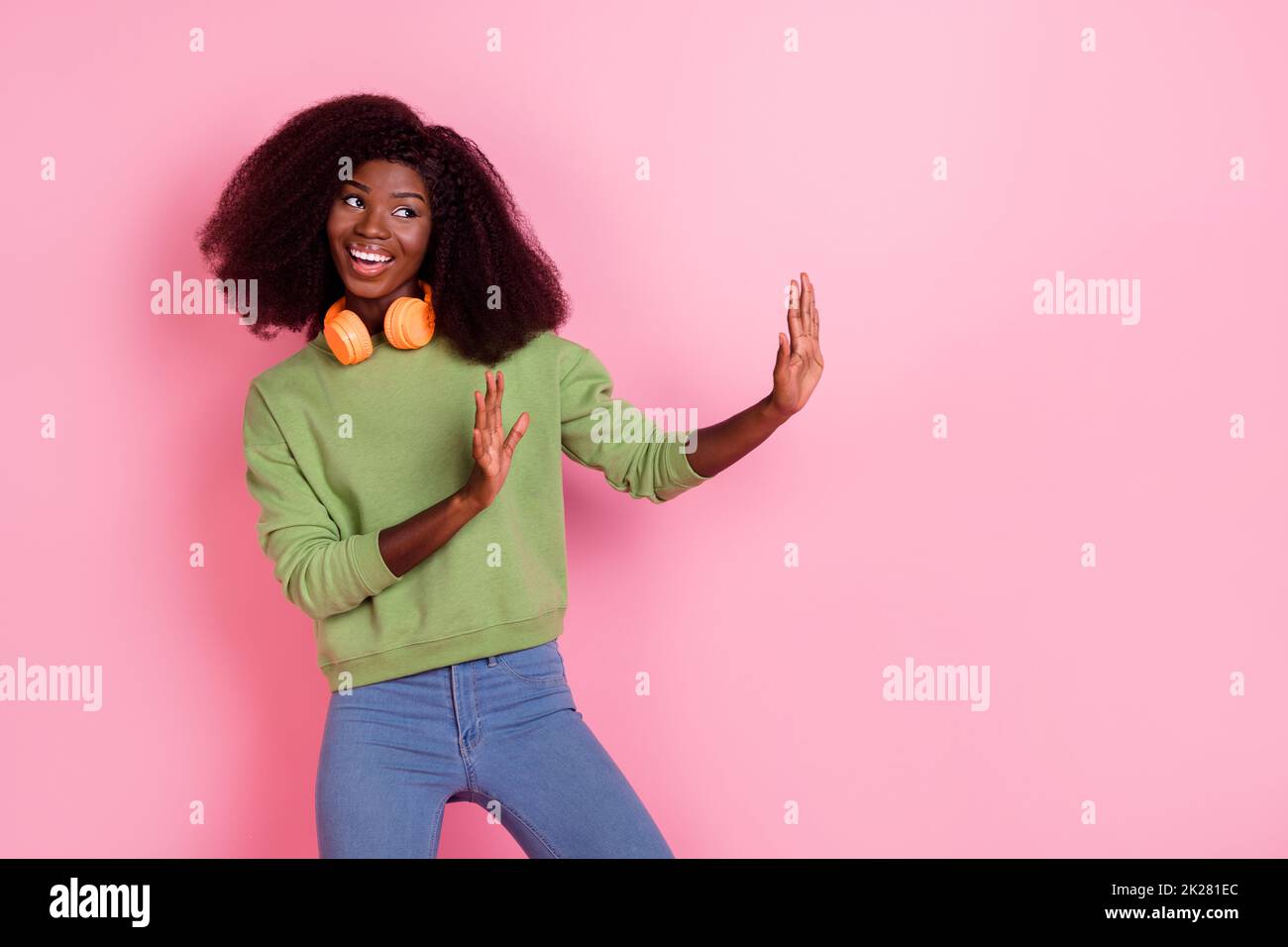 Photo of dreamy funny lady wear green sweater holding arms looking empty space isolated pink color background Stock Photo